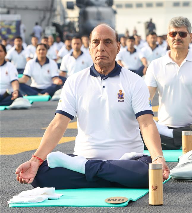 The Union Minister for Defence, Shri Rajnath Singh performs Yoga with the personnel of the Armed Forces & the Indian Coast Guard onboard INS Vikrant on the occasion of 9th International Day of Yoga on June 21, 2023. The Chief of the Naval Staff Admiral R Hari Kumar is also seen.:Ministry of Defence