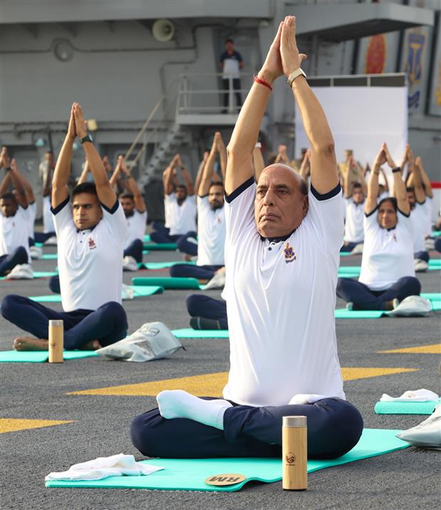 The Union Minister for Defence, Shri Rajnath Singh performs Yoga with the personnel of the Armed Forces & the Indian Coast Guard onboard INS Vikrant on the occasion of 9th International Day of Yoga on June 21, 2023. The Chief of the Naval Staff Admiral R Hari Kumar is also seen.:Ministry of Defence