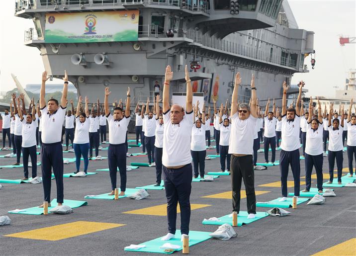 The Union Minister for Defence, Shri Rajnath Singh performs Yoga with the personnel of the Armed Forces & the Indian Coast Guard onboard INS Vikrant on the occasion of 9th International Day of Yoga on June 21, 2023. The Chief of the Naval Staff Admiral R Hari Kumar is also seen.:Ministry of Defence
