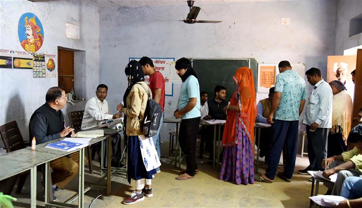 Polling official administering indelible ink to a voter, at a polling booth during the Rajasthan Legislative Assembly election 2023 at Bassi, in Jaipur on November 25, 2023.