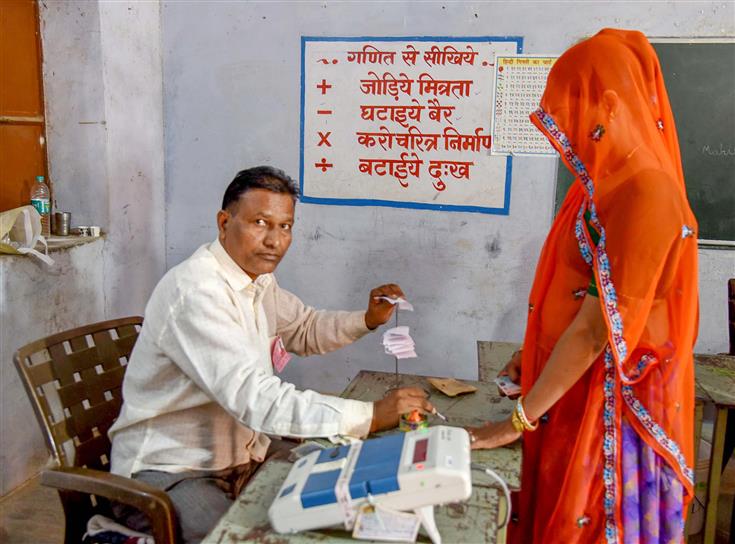 Polling official administering indelible ink to a voter, at a polling booth during the Rajasthan Legislative Assembly election 2023 at Bassi, in Jaipur on November 25, 2023.