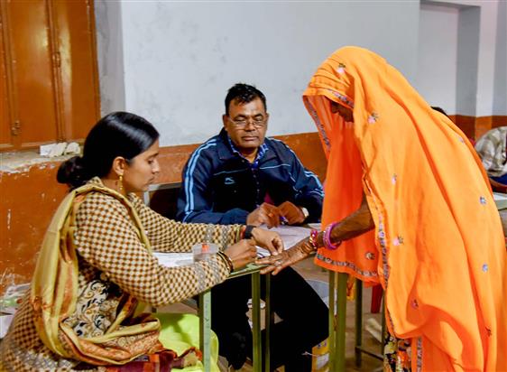 Polling official administering indelible ink to a voter, at a polling booth during the Rajasthan Legislative Assembly election 2023 at Bassi, in Jaipur on November 25, 2023.