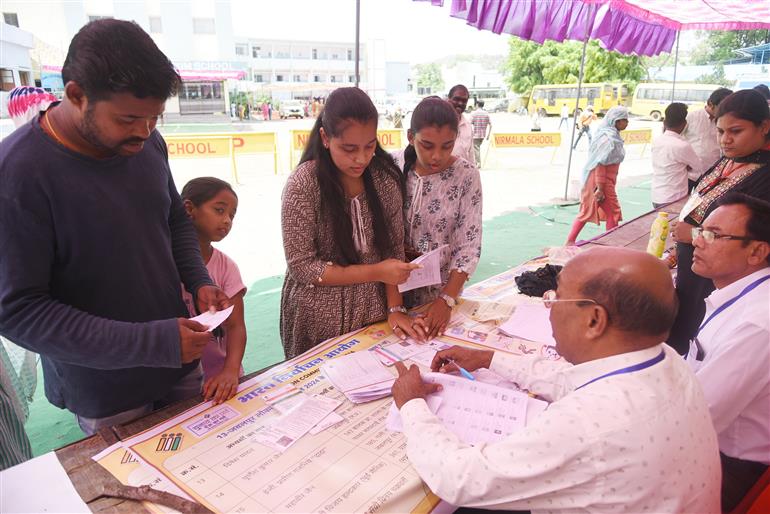 The Polling official checking the name and documents of the voters, at a polling booth, during the 1st Phase of General Elections-2024 at Nirmala English Medium School Kanchghar Chowk, East Ghamapur, Jabalpur, in Madhya Pradesh on April 19, 2024.