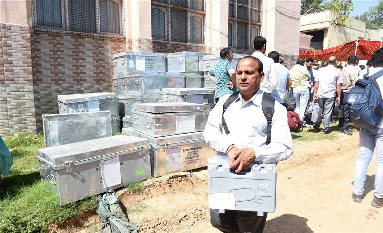 Polling officials are carrying the Electronic Voting Machine (EVMs) and other election related material required for the 2nd Phase General Elections-2024 at the Distribution Center Govt Girls Model Higher Secondary School Kandoli Nagrota, in Jammu on April 25, 2024.