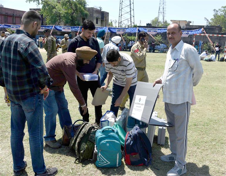 Polling officials are carrying the Electronic Voting Machine (EVMs) and other election related material required for the 2nd Phase General Elections-2024 at the Distribution Center Govt Girls Model Higher Secondary School Kandoli Nagrota, in Jammu on April 25, 2024.