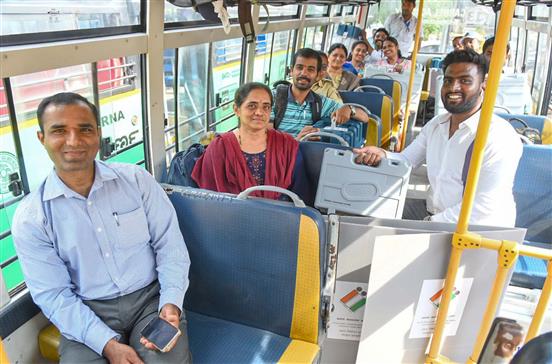 Polling officers are seated in a bus with Electronic Voting Machines (EVMs)/Ballot units and other election-related materials ready to transport them to the polling booths for the 2nd Phase General Elections 2024 at BBMP PU College, Chamrajpet, in Bangalore on April 25, 2024.