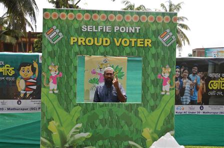 01 जून, 2024 को पश्चिम बंगाल के जयनगर में आम चुनाव-2024 के सातवें चरण के दौरान एक मतदान केंद्र पर अपना वोट डालने के बाद सेल्फी प्वाइंट पर अमिट स्याही का निशान दिखाता हुआ एक मतदाता।