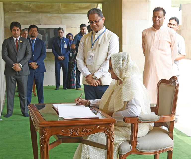 The Prime Minister of Bangladesh, Smt. Sheikh Hasina writing her remarks in the visitor book after visiting the Samadhi of Mahatma Gandhi at Rajghat, in New Delhi on June 22, 2024.
