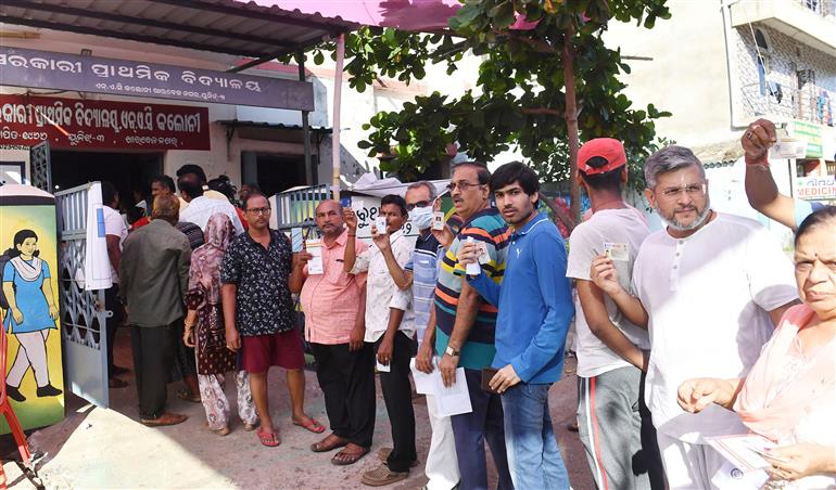 Voters displaying identity cards while standing in queue to cast their votes at a polling booth during the 6th Phase of General Elections-2024 at Govt Primary School NAC Colony in Bhubaneswar, Odisha on May 25, 2024.