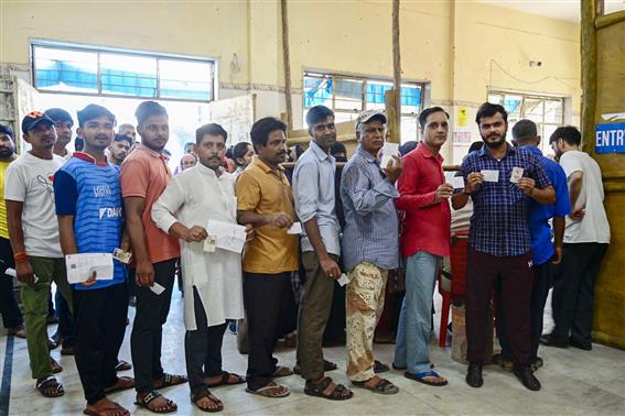 Voters displaying identity cards while standing in queue to cast their votes at a polling booth during the 6th Phase of General Elections-2024 at Silai Prashikshan Kendra, Hazrat Nizamuddin, in New Delhi on May 25, 2024.