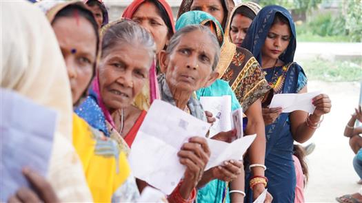 25 मई, 2024 को बिहार के महाराजगंज में आम चुनाव-2024 के छठे चरण के दौरान एक मतदान केंद्र पर वोट डालने के लिए कतार में खड़ी महिला मतदाता पहचान पत्र दिखाती हुईं।