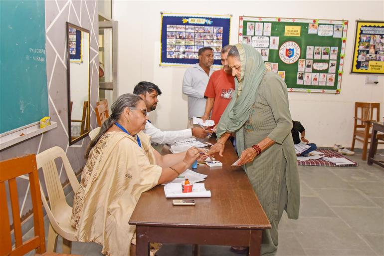 A polling official administering indelible ink to the voters after casting their votes at a polling booth during the Legislative Assembly Elections 2024 at G.V.M. Girls College in Sonipat, Haryana on October 05, 2024.
