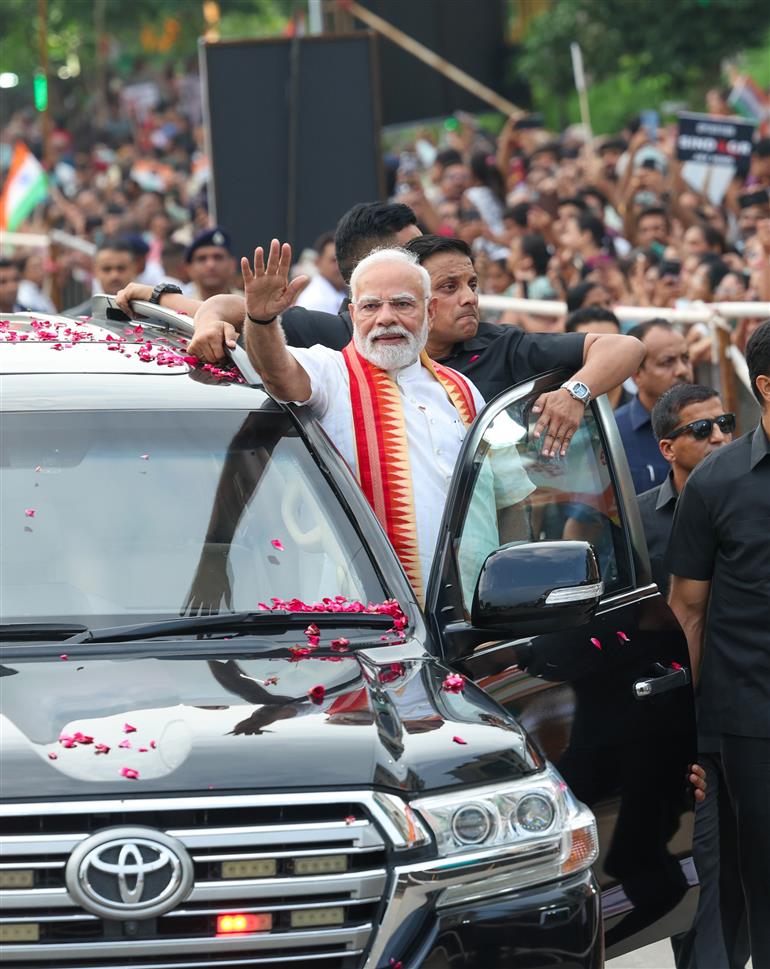 PM receives warm welcome by enthusiastic crowd during the Grand Road Show on his arrival at Ahmedabad, in Gujarat on August 25, 2025. 