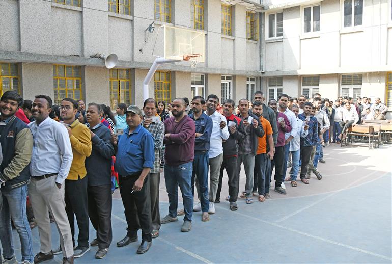 Voters standing in the queue to cast their votes at a polling booth during the Delhi Assembly Election 2025 at Atal Adarsh Vidyalaya, Laxmi Bai Nagar, in New Delhi on February 05, 2025.