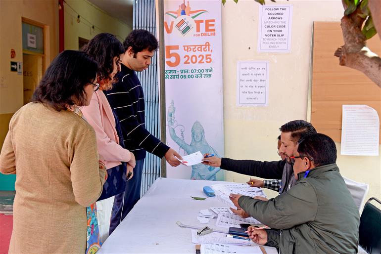 The Voters are being assisted by election officials at a polling booth during the Delhi Assembly Election 2025 at Gole Market, in New Delhi on February 05, 2025.