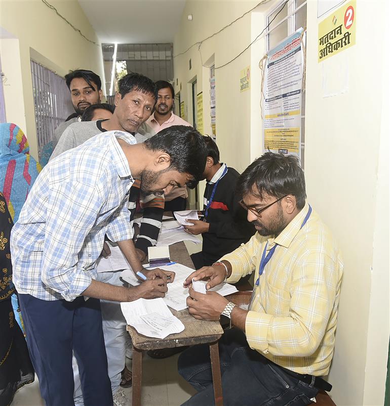 बिहार विधानसभा चुनाव 2025 के दूसरे चरण के दौरान 11 नवंबर, 2025 को बिहार के गया में हरिदास सेमिनरी इंटर कॉलेज में एक मतदान केंद्र पर मतदाताओं के नाम और दस्तावेजों की जांच करते मतदान अधिकारी।