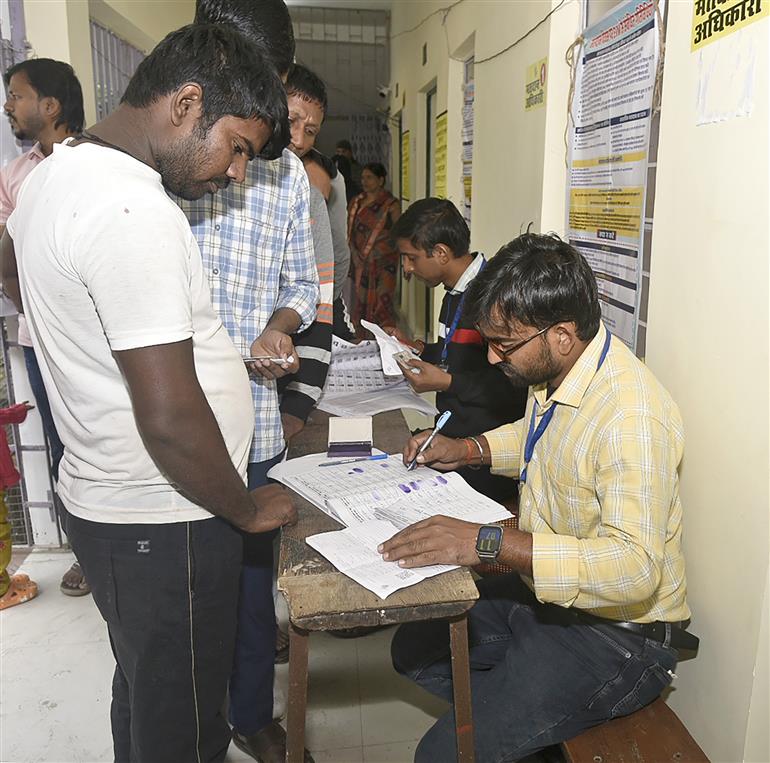 बिहार विधानसभा चुनाव 2025 के दूसरे चरण के दौरान 11 नवंबर, 2025 को बिहार के गया में हरिदास सेमिनरी इंटर कॉलेज में एक मतदान केंद्र पर मतदाताओं के नाम और दस्तावेजों की जांच करते मतदान अधिकारी।