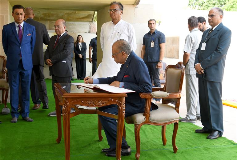 The Prime Minister of the Republic of Mauritius, Dr. Navinchandra Ramgoolam writing his remarks in the visitor book at the Samadhi of Mahatma Gandhi at Rajghat, in Delhi on September 16, 2025.