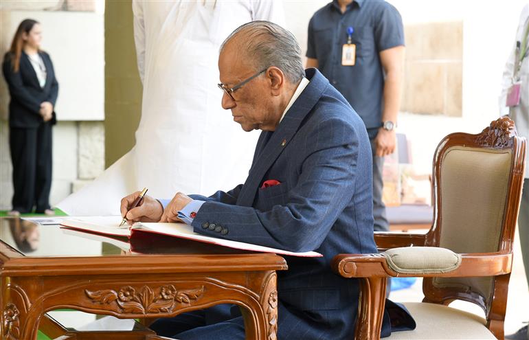 The Prime Minister of the Republic of Mauritius, Dr. Navinchandra Ramgoolam writing his remarks in the visitor book at the Samadhi of Mahatma Gandhi at Rajghat, in Delhi on September 16, 2025.