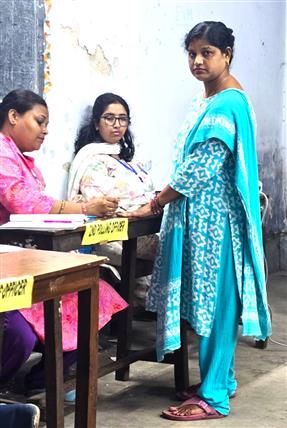 29 अप्रैल, 2026 को पश्चिम बंगाल में पश्चिम बंगाल विधानसभा चुनाव 2026 के दूसरे चरण के दौरान रवींद्र भारती विश्वविद्यालय के एक मतदान केंद्र पर मतदाताओं को अमिट स्याही लगाते हुए एक मतदान अधिकारी।  