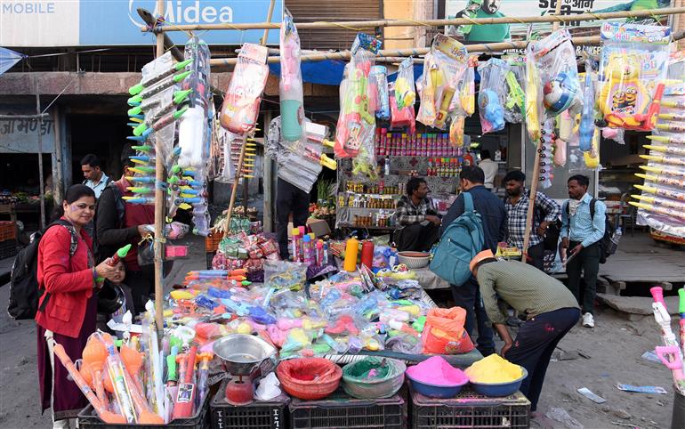 03 मार्च, 2026 को उत्तर प्रदेश के गाजियाबाद में होली के त्योहार से पहले लोग होली के रंग और पिचकारी खरीदते हुए।