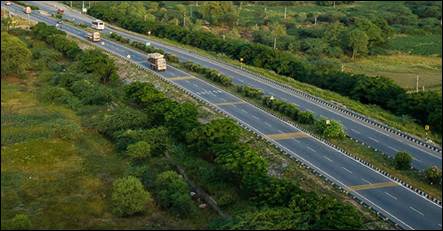 A highway with trees and bushesAI-generated content may be incorrect.