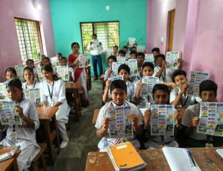 A group of people in a classroom holding up papersAI-generated content may be incorrect.