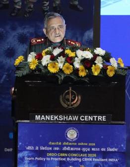 A person standing at a podium with flowersDescription automatically generated