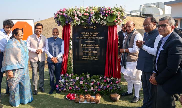 A group of men standing in front of a black signDescription automatically generated