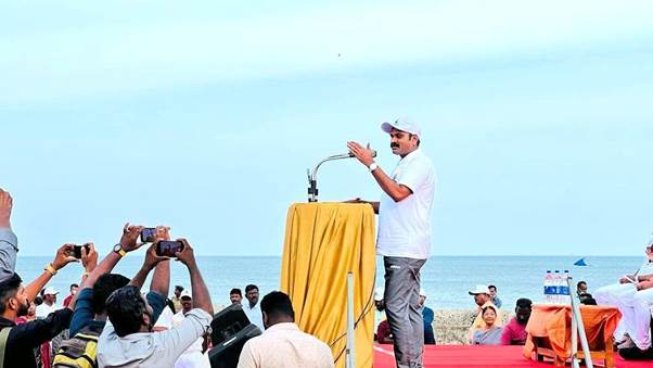 A person standing on a boat with a crowd watchingDescription automatically generated with low confidence