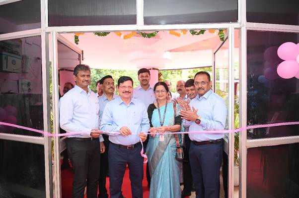 A group of people standing in front of a ribbon cuttingDescription automatically generated