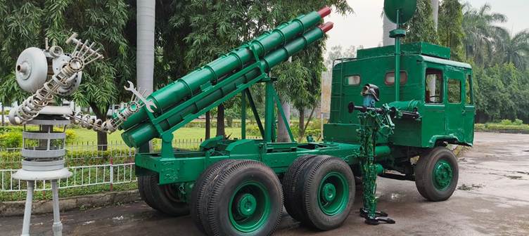 A green military vehicle with a cannonDescription automatically generated