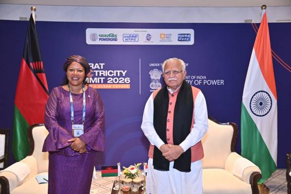 A group of people standing in front of a blue wallDescription automatically generated