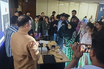 A person speaking into a microphone with a group of people around himAI-generated content may be incorrect.