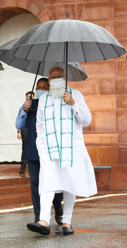 New Delhi, India. 19th July, 2021. Prime Minister Narendra Modi holds an  umbrella to protect from the rain as he addresses the media on the opening  day of the monsoon session of