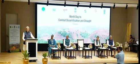 The image depicts a conference room setting with a presentation on the World Day to Combat Desertification and Drought, featuring a speaker and a Q&A session.AI-generated content may be incorrect.