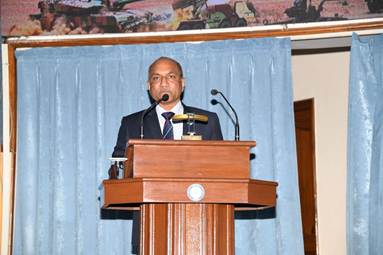 A person standing at a podium with microphonesDescription automatically generated