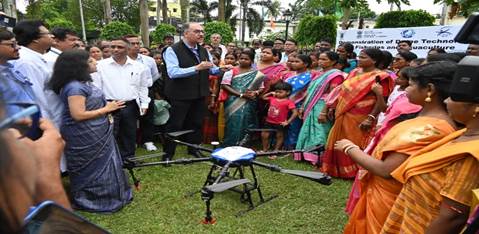 A group of people standing around a droneDescription automatically generated