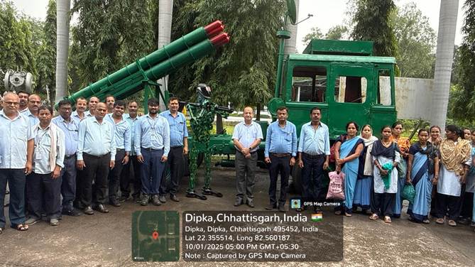 A group of people standing in front of a green military vehicleDescription automatically generated