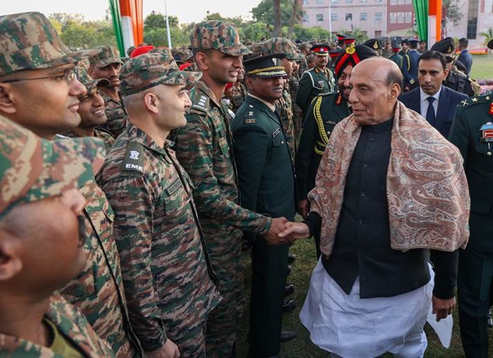 A person shaking hands with a group of people in military uniformsDescription automatically generated