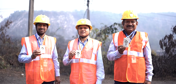 A group of men wearing orange vests and hard hatsDescription automatically generated