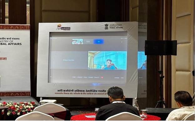 A person sitting at a table with a large screenAI-generated content may be incorrect.
