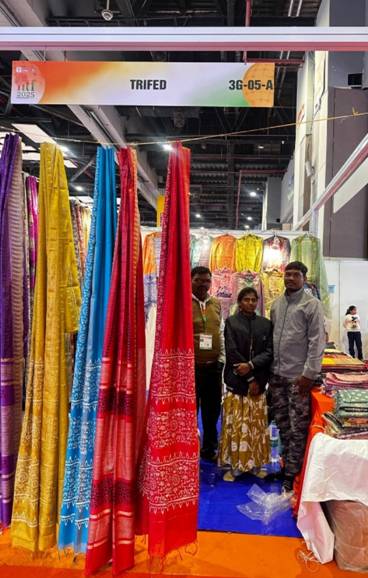 A group of people standing in a room with colorful fabricAI-generated content may be incorrect.