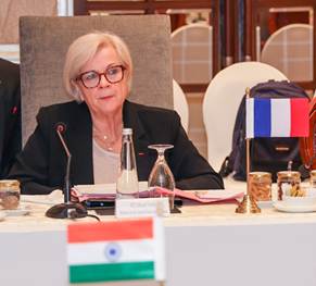 A person sitting at a table with a microphoneDescription automatically generated