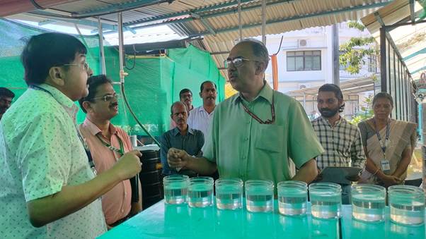 A group of people standing around a table with glasses of waterDescription automatically generated