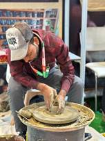 A person working on a pottery wheelAI-generated content may be incorrect.