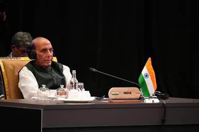 A person sitting at a desk with a microphoneDescription automatically generated