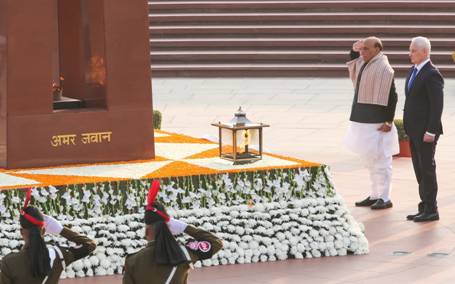 A person standing next to a statueDescription automatically generated