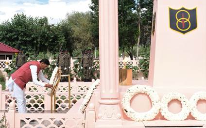 A person placing a wreath on a monumentDescription automatically generated