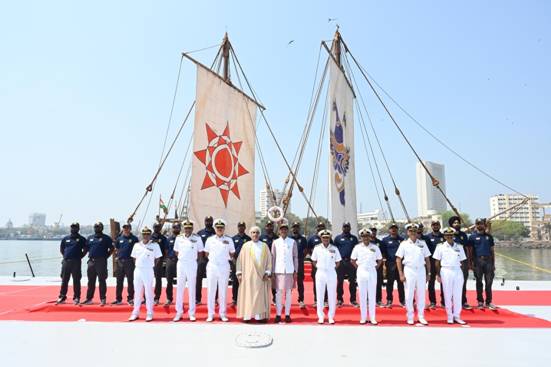 A group of people in uniform standing in front of flagsDescription automatically generated